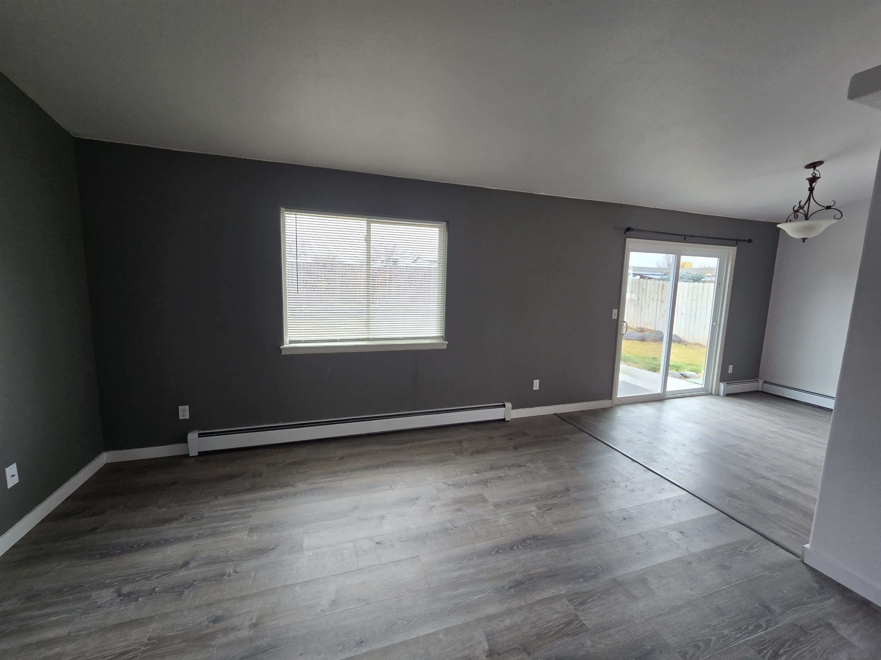 1400 Powell Street Fruita, CO 81521 - Photo 7 of 21 an empty room with wooden floor and windows