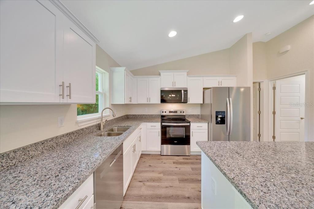 10675 Southwest 69th Terrace Ocala, FL 34476 - Photo 18 of 48 a kitchen with stainless steel appliances granite countertop a sink stove and refrigerator