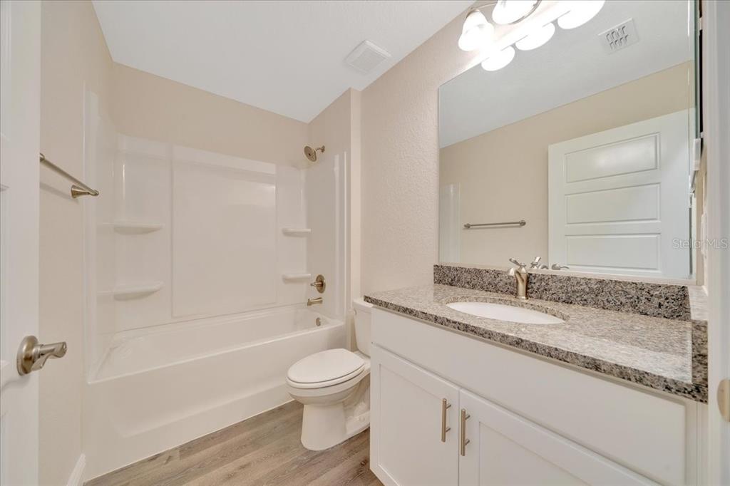 10675 Southwest 69th Terrace Ocala, FL 34476 - Photo 29 of 48 a bathroom with a granite countertop sink a toilet and bathtub