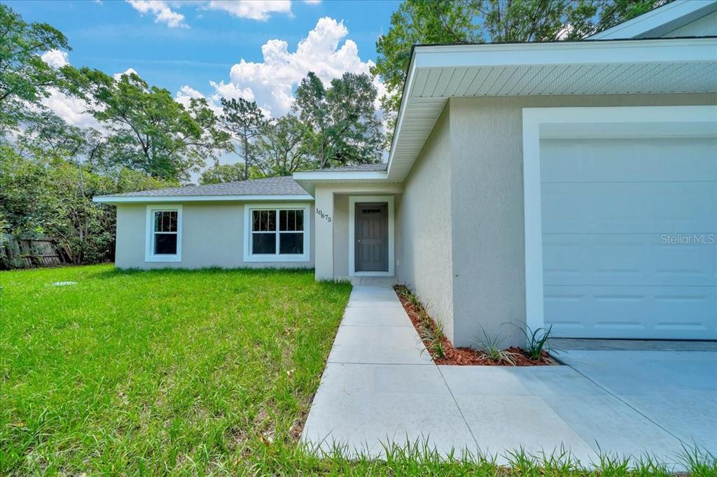 10675 Southwest 69th Terrace Ocala, FL 34476 - Photo 5 of 48 a front view of a house with a yard