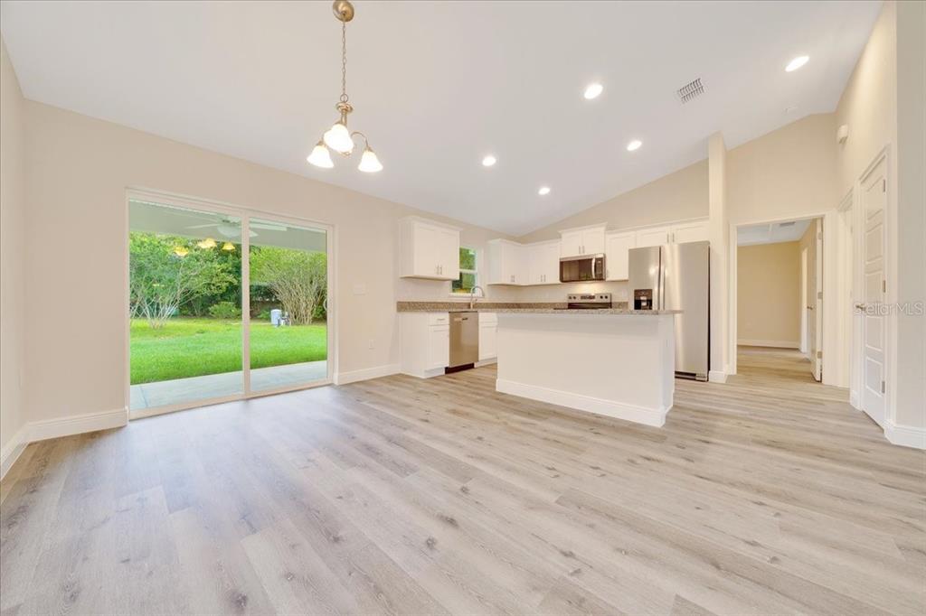 10675 Southwest 69th Terrace Ocala, FL 34476 - Photo 7 of 48 a view of a kitchen with wooden floor and a window