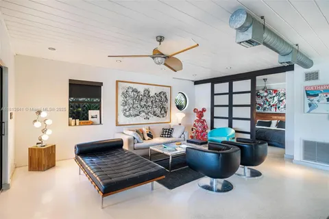 a living room with furniture a large window and a chandelier