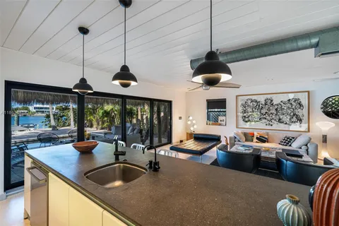 a view of a patio with couches and chairs under an umbrella