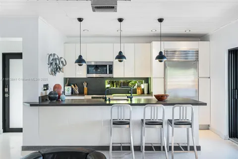 a kitchen with stainless steel appliances granite countertop a sink and refrigerator