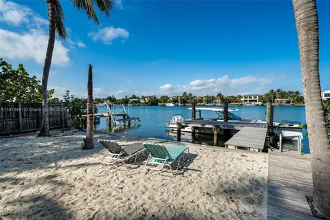 a view of a swimming pool with a lounge chair and palm trees