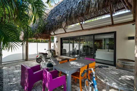 a kitchen with kitchen island granite countertop a table chairs stove a refrigerator and cabinets