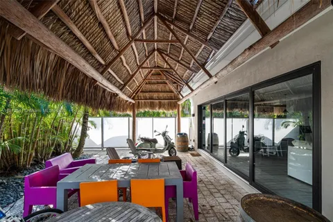 a living room with furniture kitchen view and a wooden floor