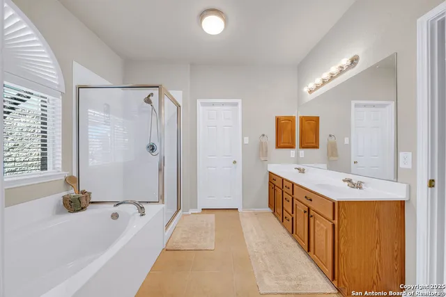 a bathroom with a tub sink shower and mirror
