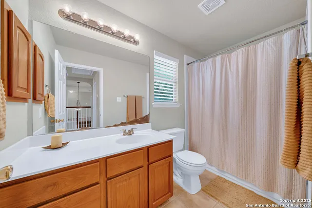 a bathroom with a double vanity sink toilet and a mirror