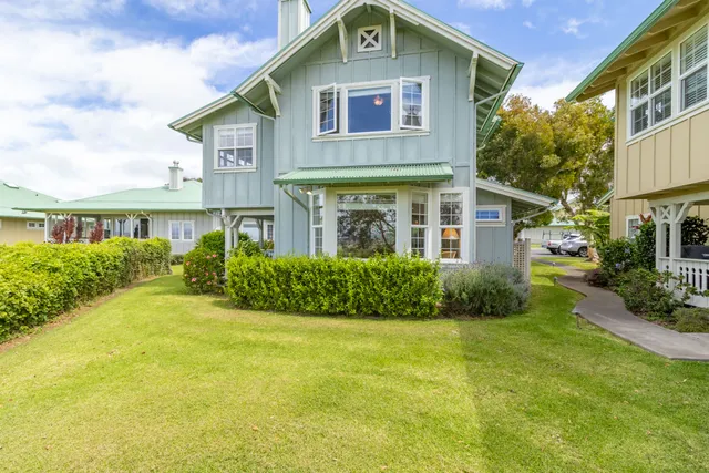 a front view of a house with a yard and plants