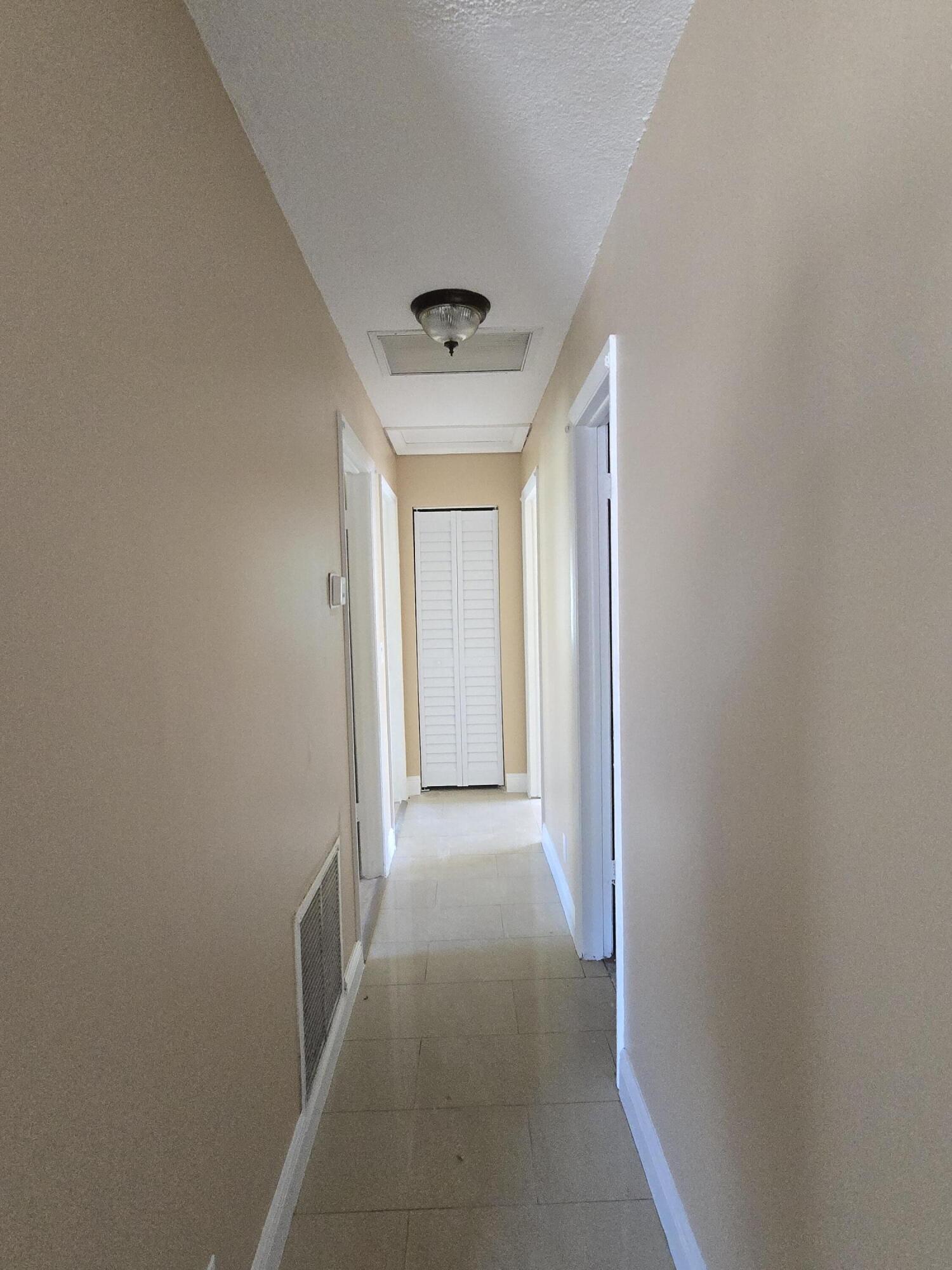 815 Silver Beach Road Lake Park, FL 33403 - Photo 5 of 7 a view of a hallway to a house with wooden floor and a window