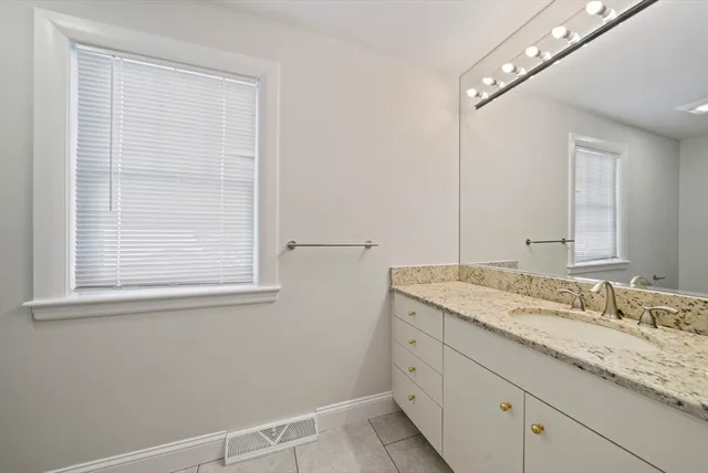 a bathroom with a granite countertop sink and a mirror