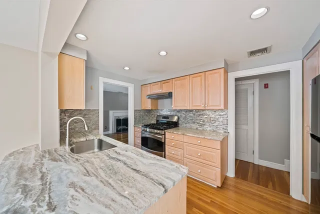 a kitchen with granite countertop a stove and a sink