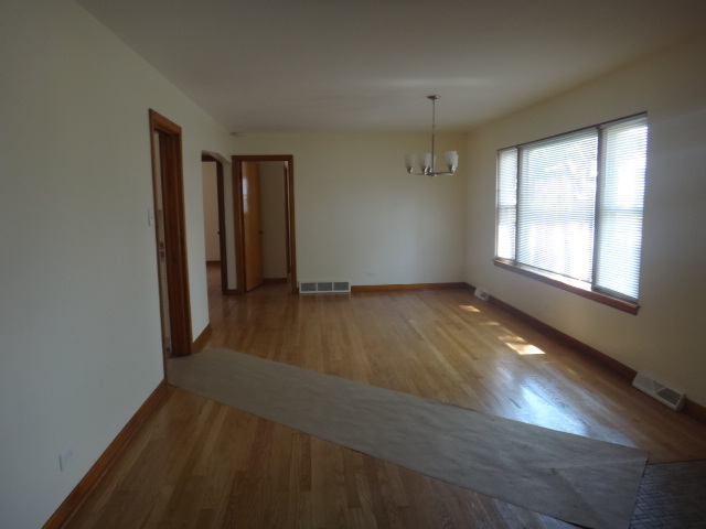 4044 Clinton Avenue Stickney, IL 60402 - Photo 3 of 11 an empty room with wooden floor and windows
