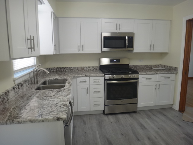 4044 Clinton Avenue Stickney, IL 60402 - Photo 6 of 11 a kitchen with granite countertop a stove a sink and a microwave