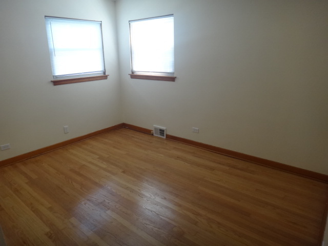 4044 Clinton Avenue Stickney, IL 60402 - Photo 9 of 11 an empty room with wooden floor and windows