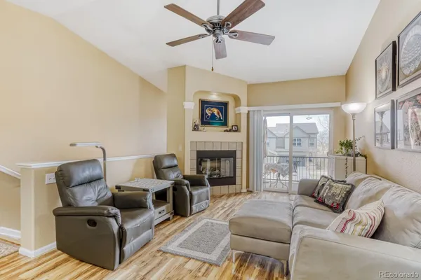 a living room with furniture a fireplace and a large window