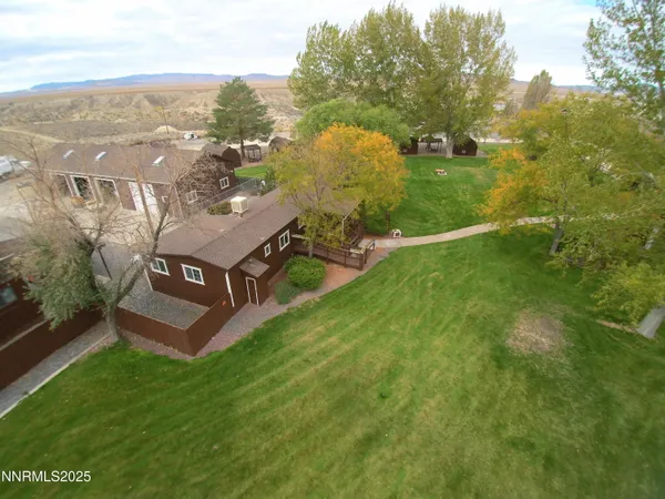 an aerial view of residential houses with outdoor space and trees