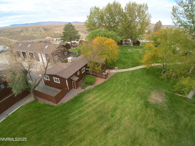an aerial view of residential houses with outdoor space and trees