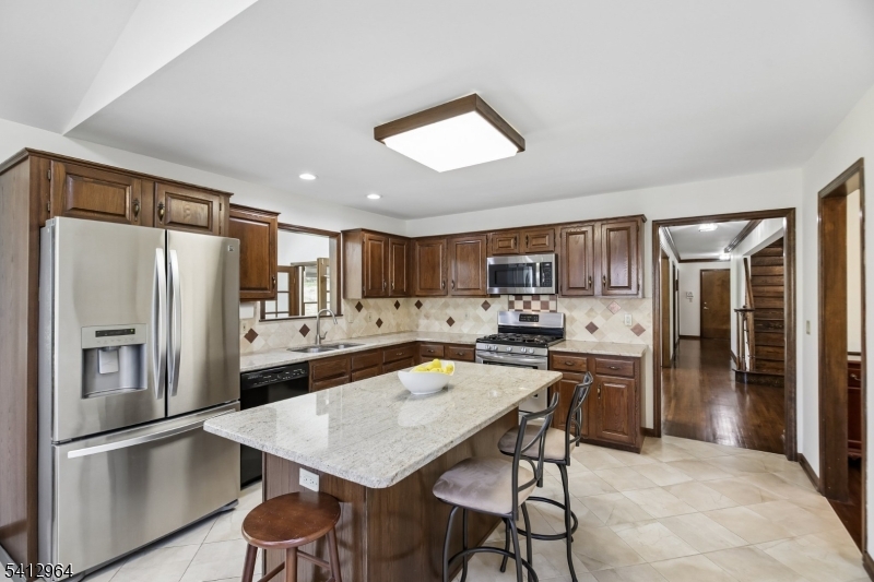 34 Knollcroft Road Bernards, NJ 07920 - Photo 12 of 34 a kitchen with stainless steel appliances a refrigerator and a stove top oven