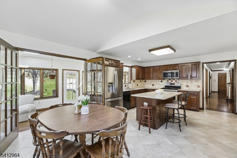 34 Knollcroft Road Bernards, NJ 07920 - Photo 13 of 34 a kitchen with a dining table chairs and large windows