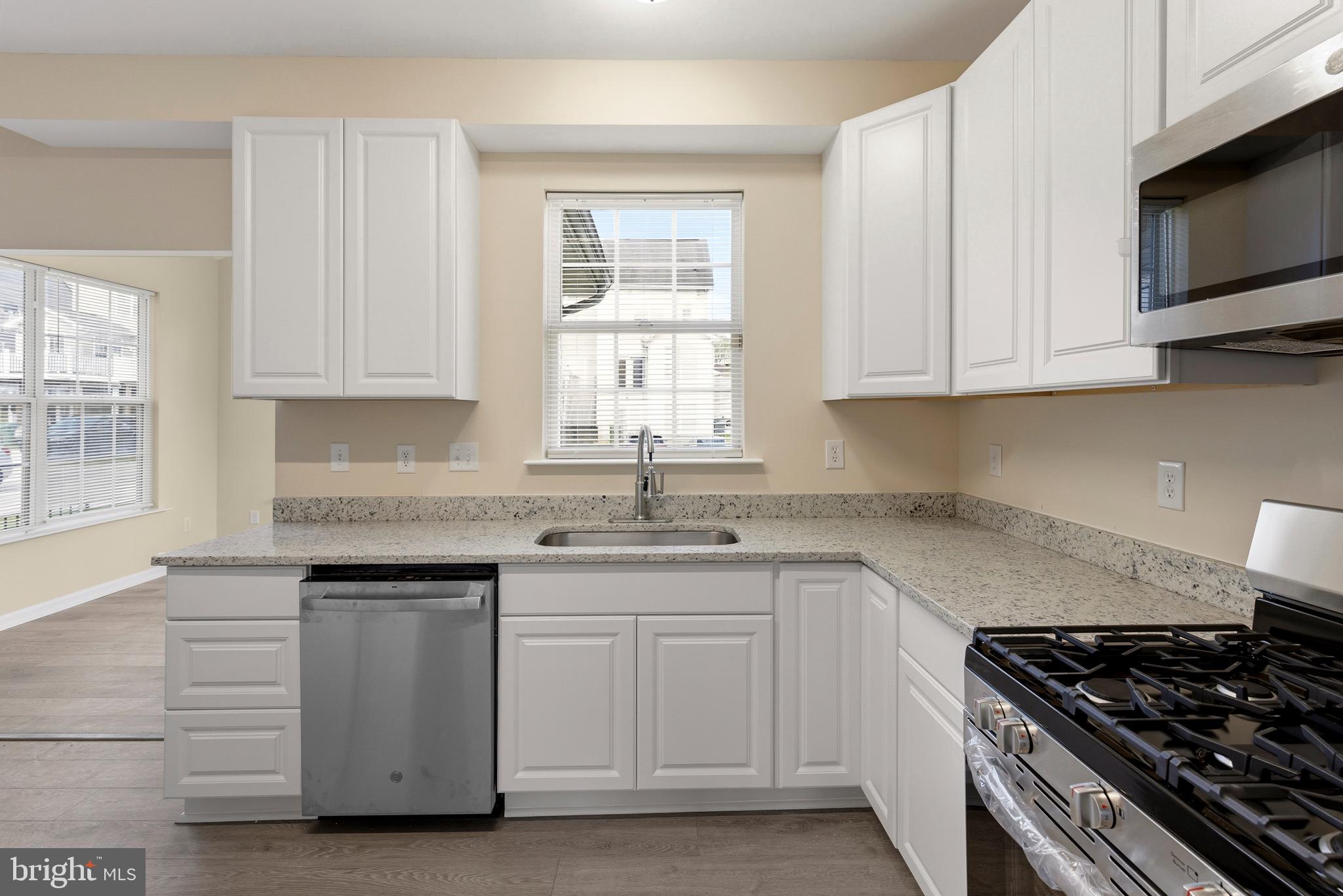 4704 Denview Way Baltimore, MD 21206 - Photo 8 of 42 a kitchen with granite countertop white cabinets and a stove top oven