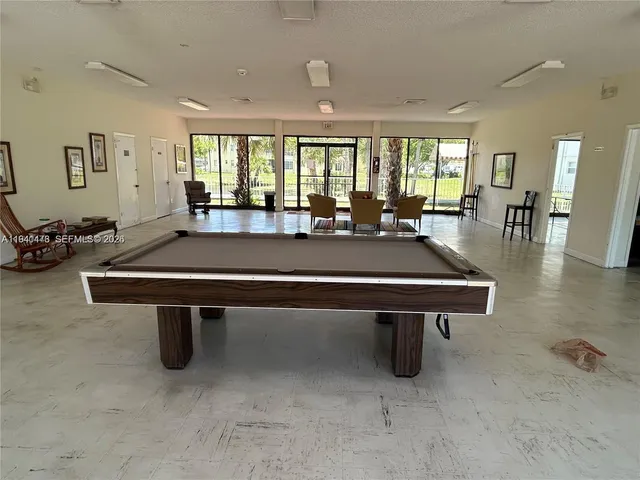 a room with furniture pool table and windows