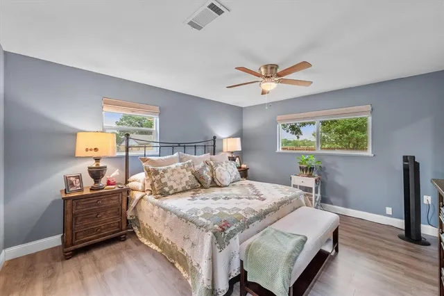 a bedroom with a bed a dresser and a window