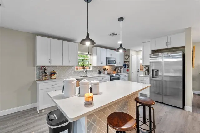 a kitchen with kitchen island a stove a table and chairs