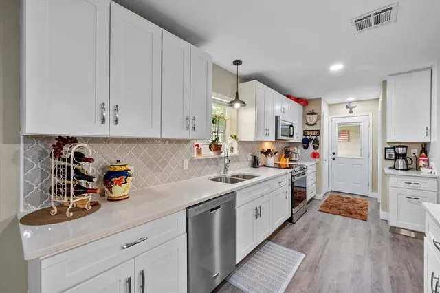 a kitchen with stainless steel appliances granite countertop a sink stove and cabinets