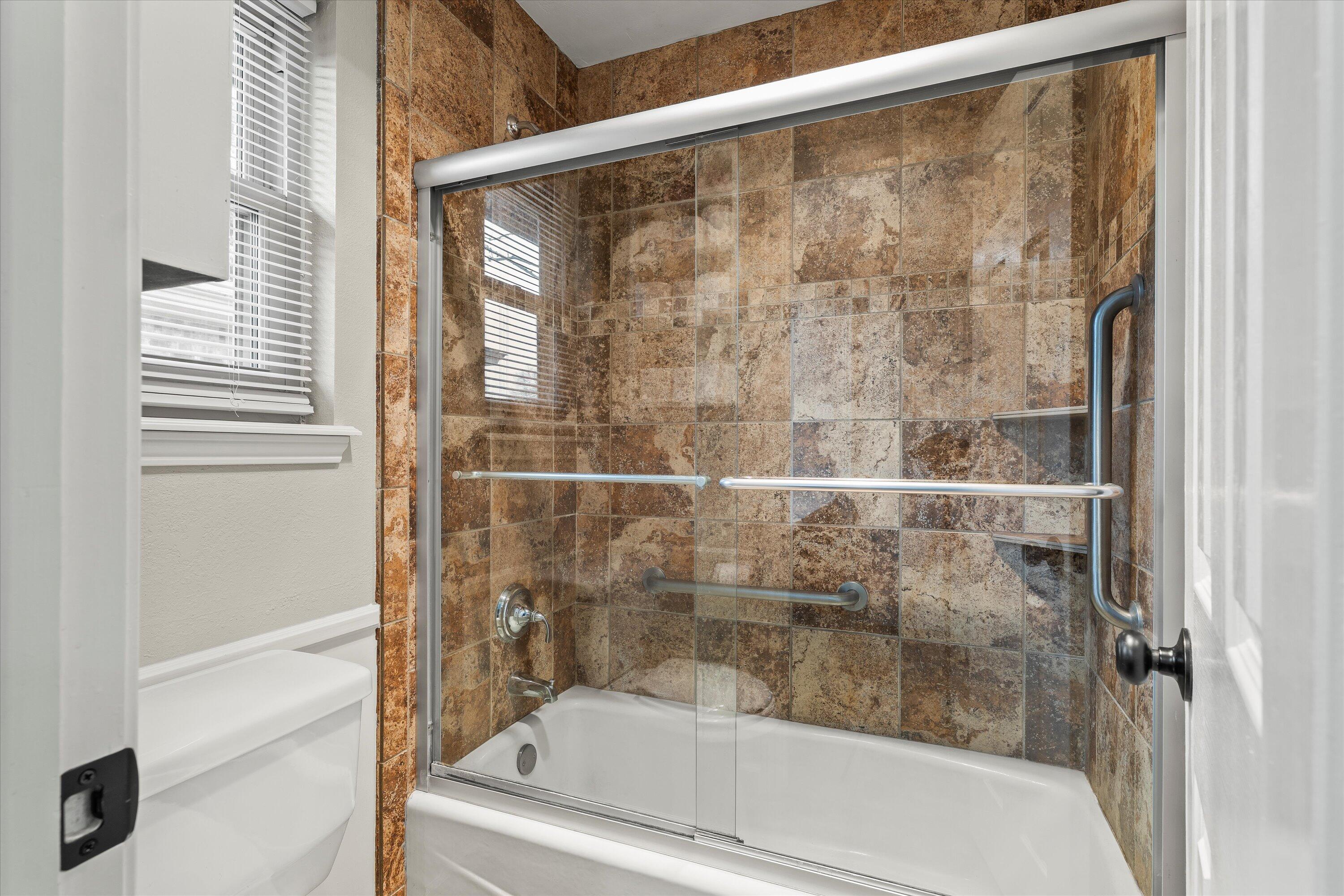 5223 91st Street Lubbock, TX 79424 - Photo 16 of 29 a bathroom with a bathtub and a shower