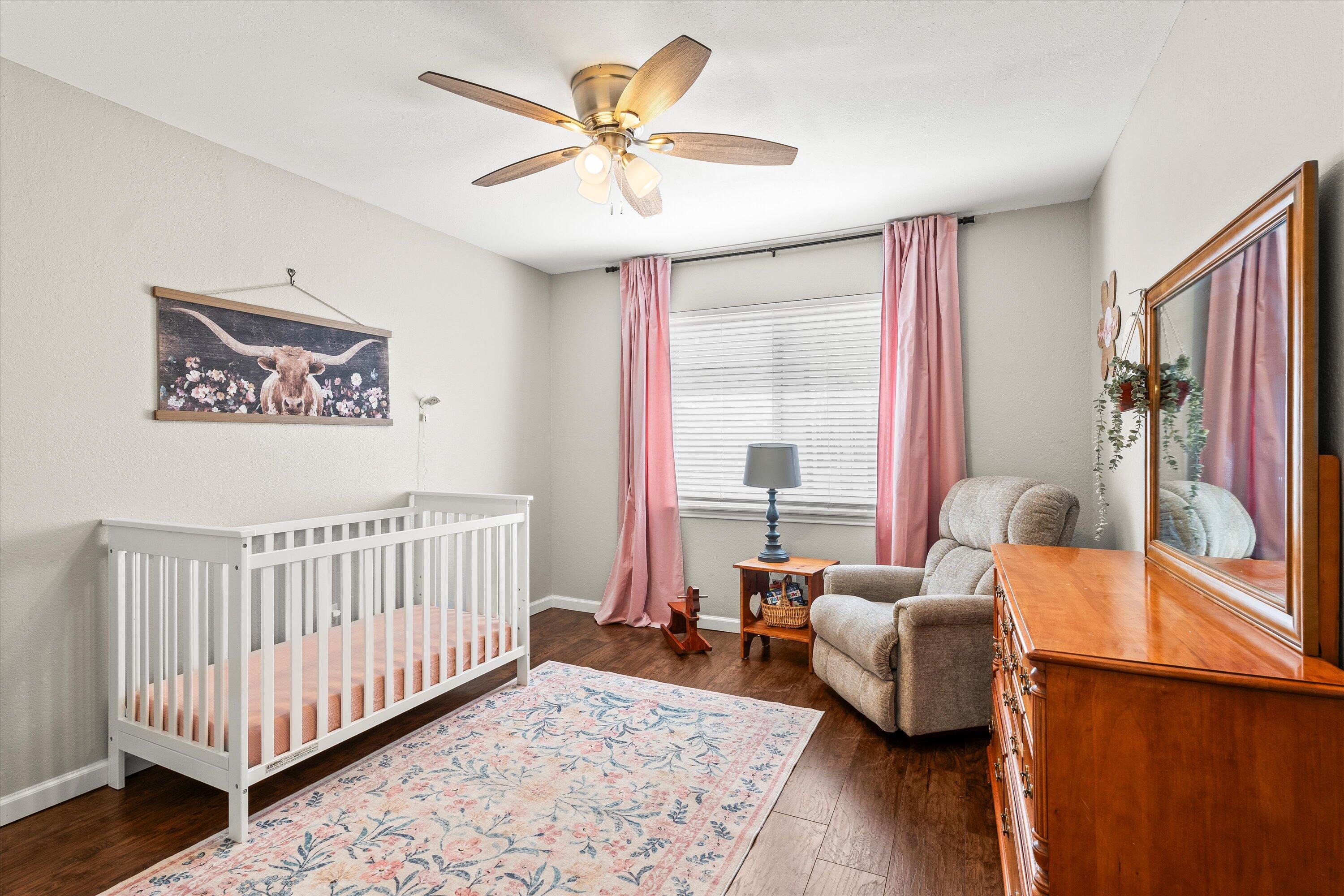 5223 91st Street Lubbock, TX 79424 - Photo 18 of 29 a bed room with furniture and wooden floor