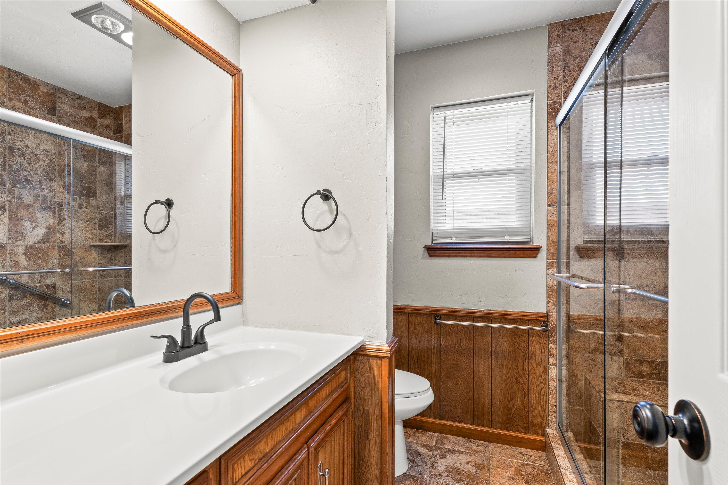 5223 91st Street Lubbock, TX 79424 - Photo 22 of 29 a bathroom with a sink a toilet and a mirror