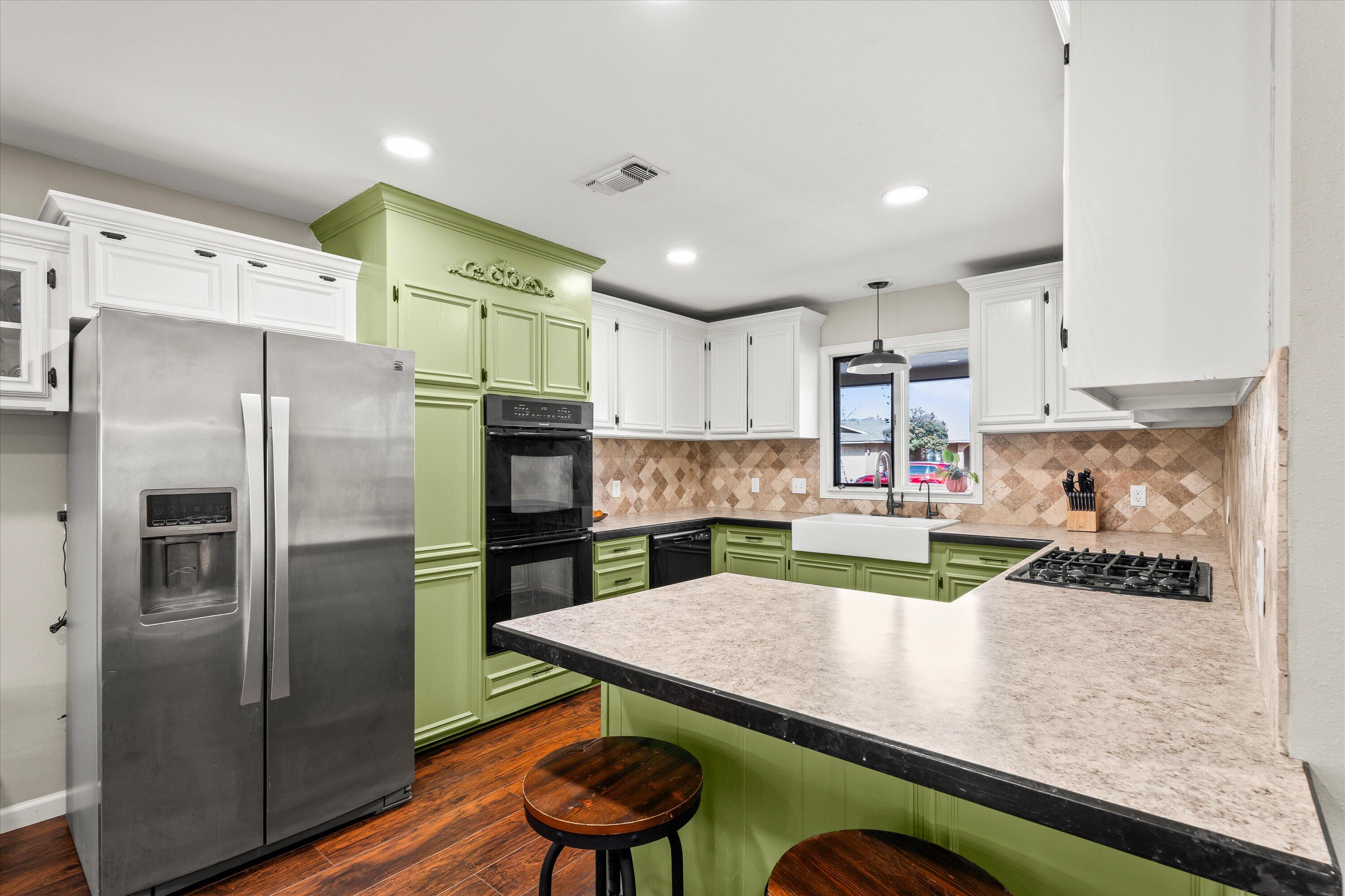 5223 91st Street Lubbock, TX 79424 - Photo 4 of 29 a kitchen with kitchen island a refrigerator and a stove