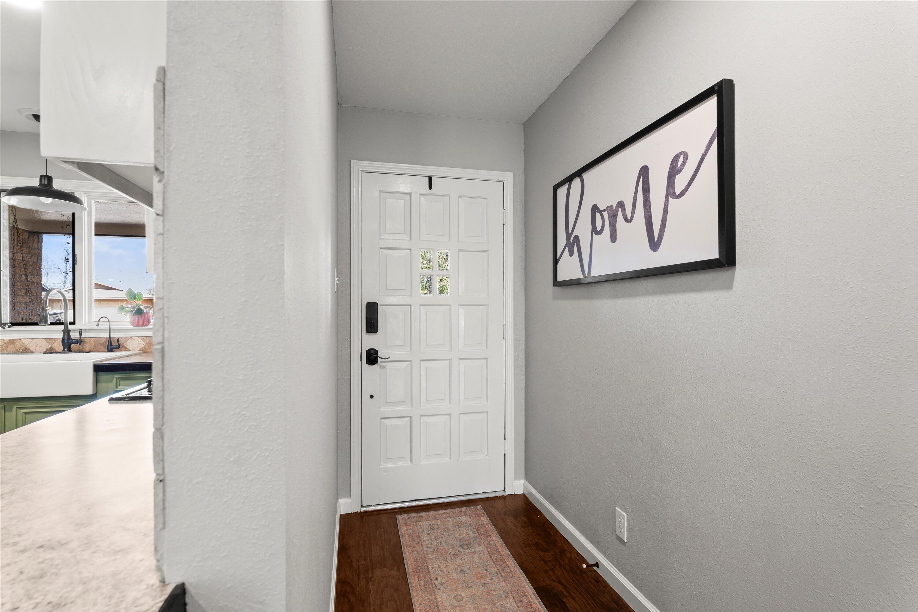 5223 91st Street Lubbock, TX 79424 - Photo 6 of 29 a view of a hallway with paintings on the wall