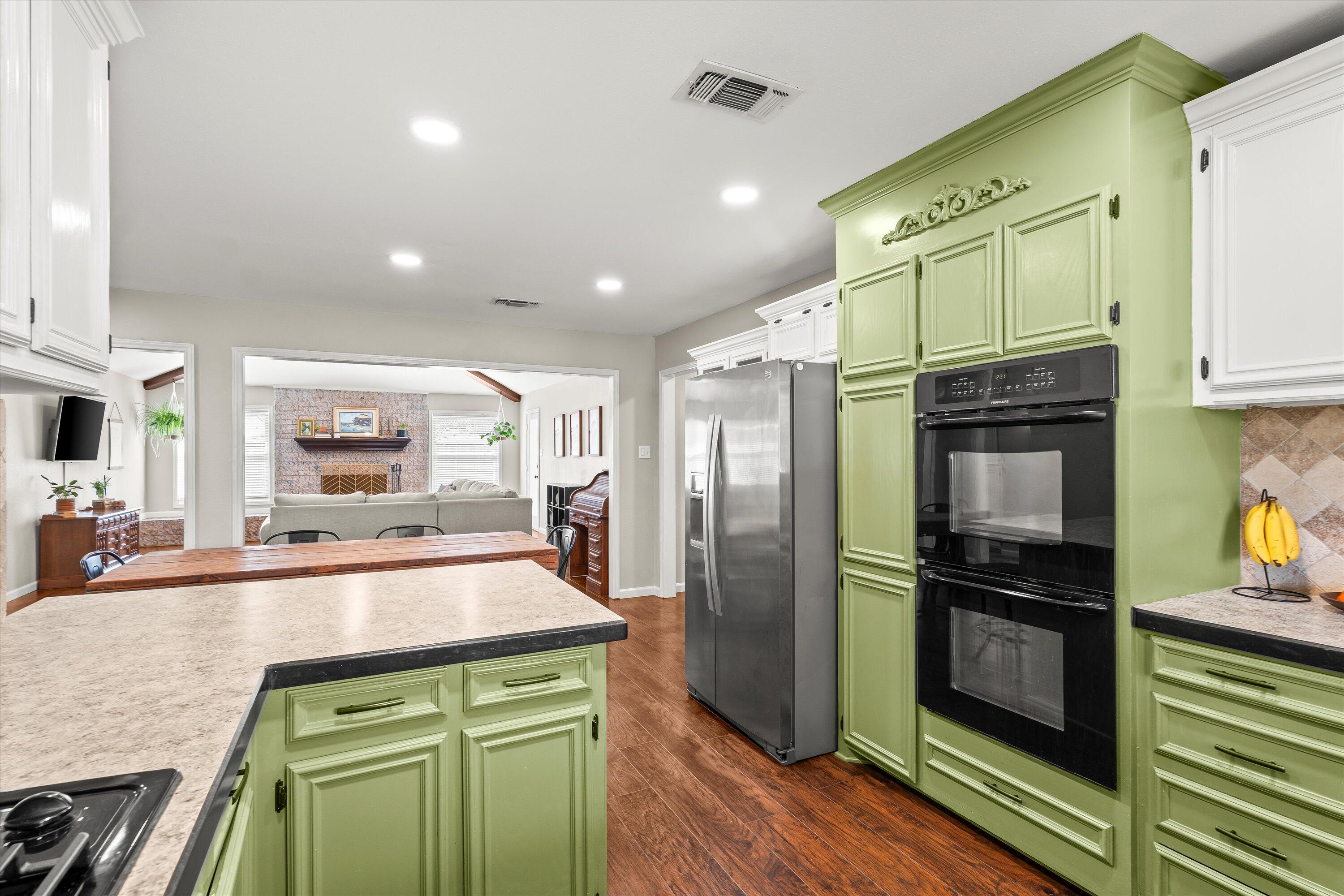 5223 91st Street Lubbock, TX 79424 - Photo 9 of 29 a kitchen with granite countertop a refrigerator and a stove top oven