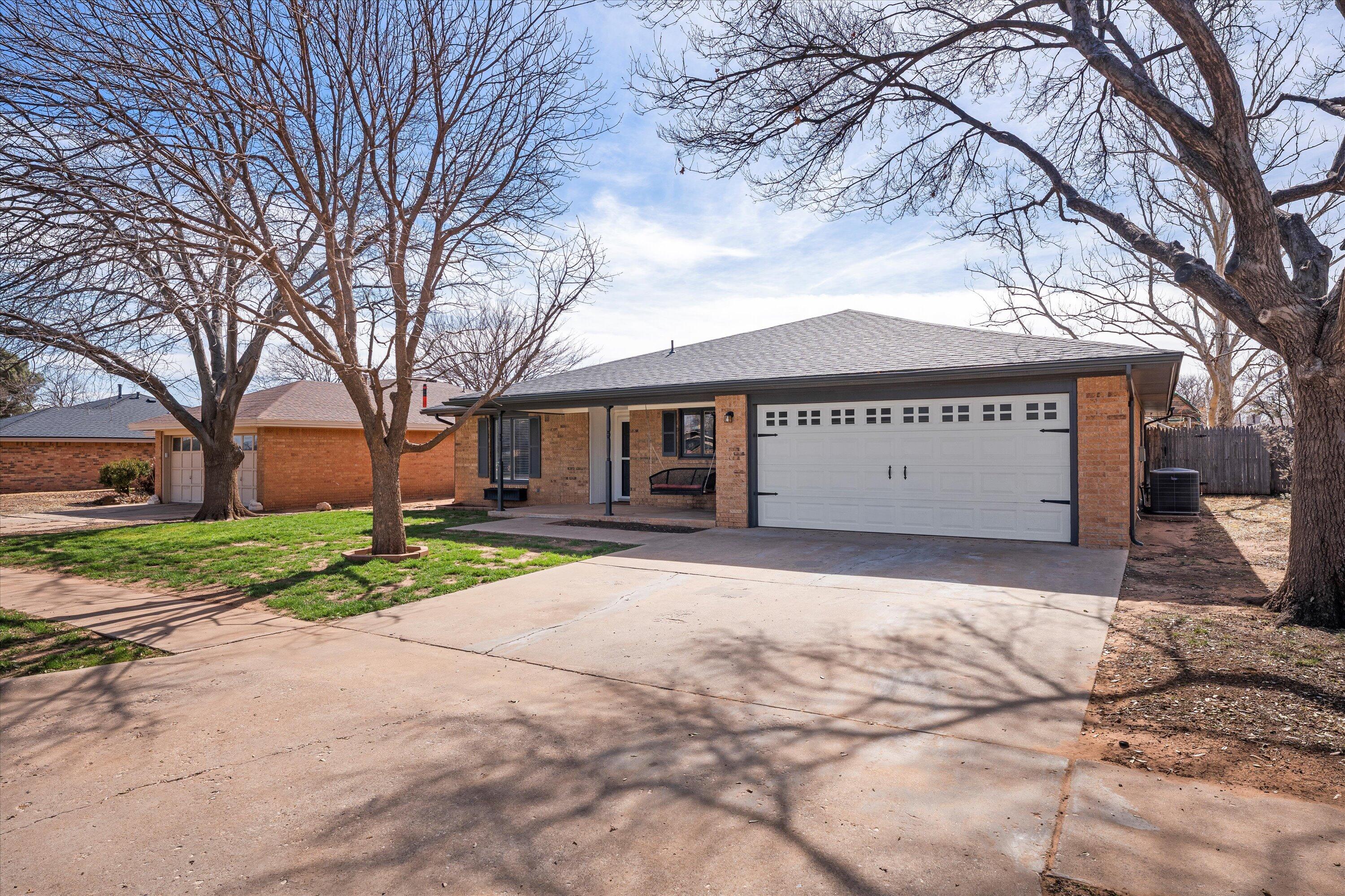 5223 91st Street Lubbock, TX 79424 - Photo 10 of 29 a front view of a house with a yard and garage
