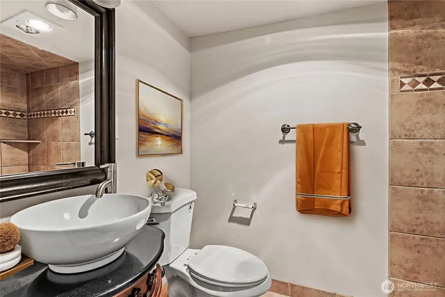 a bathroom with a toilet a sink and mirror