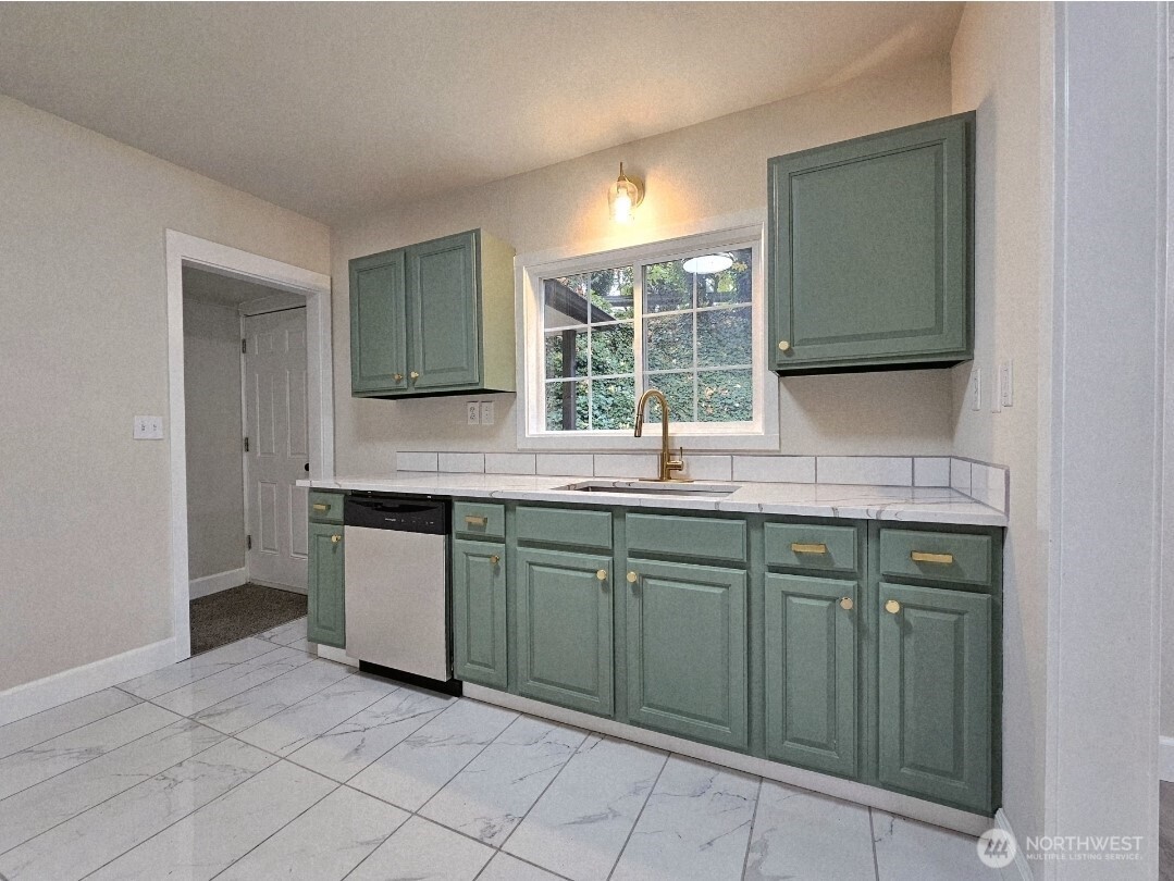 802 Northwest 5th Circle Camas, WA 98607 - Photo 6 of 26 a kitchen with granite countertop a sink and a washing machine