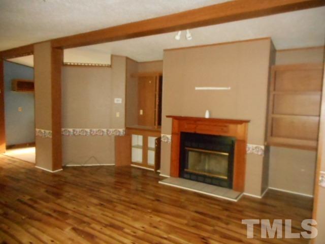 410 W Road Angier, NC 27501 - Photo 3 of 12 a view of an empty room with wooden floor and a fireplace