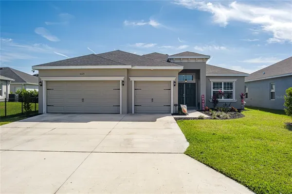 a front view of a house with a yard and garage