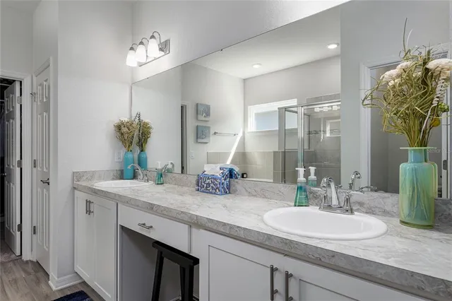 a bathroom with a granite countertop sink a large mirror and a shower