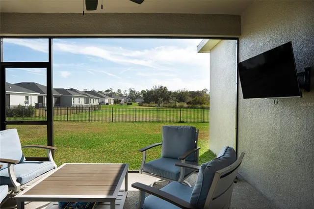 a view of a chairs and table in patio with a yard