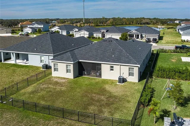 an aerial view of residential houses with outdoor space and parking