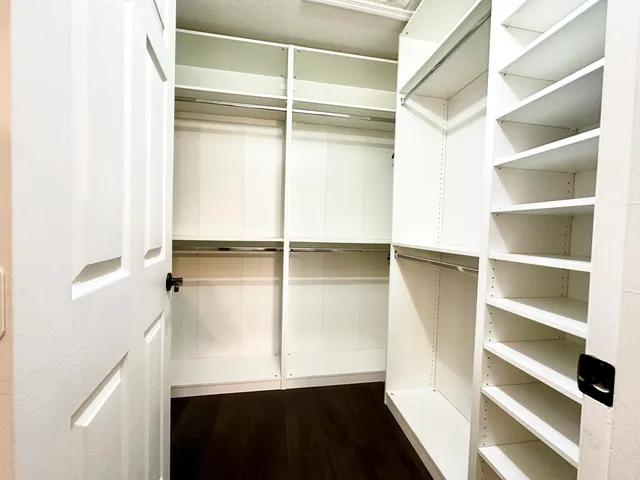a view of walk in closet with empty racks