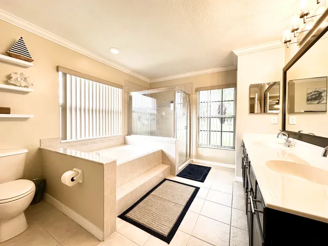 a spacious bathroom with a granite countertop sink and a large mirror next to a window