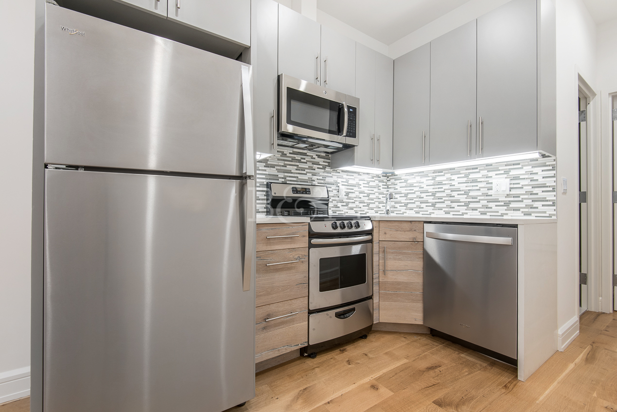 a kitchen with granite countertop cabinets stainless steel appliances and a refrigerator