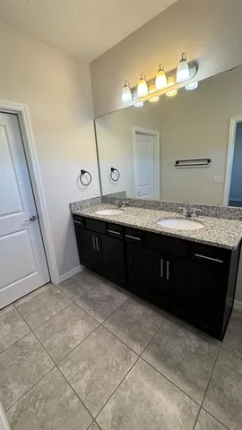 a bathroom with a granite countertop sink a mirror and a vanity