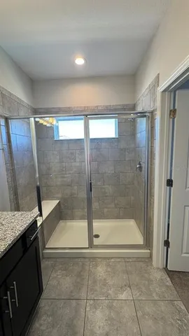 a bathroom with a granite countertop bathtub shower and sink