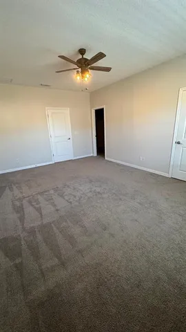 a view of an empty room and a ceiling fan